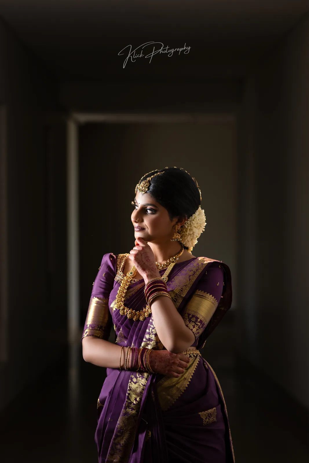 Low-key studio portrait of a bride in traditional silk