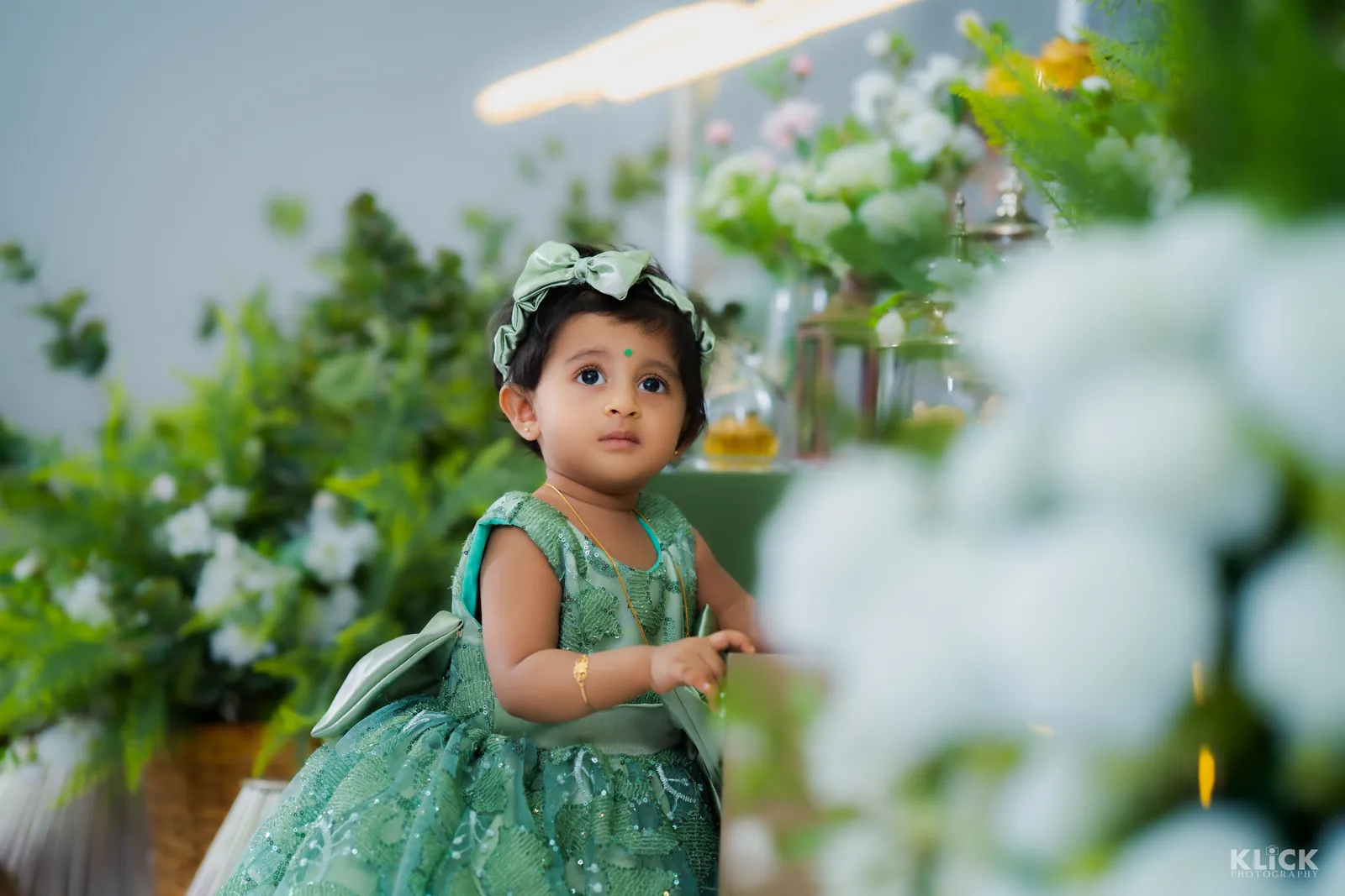 Toddler in a green dress photographed outdoors