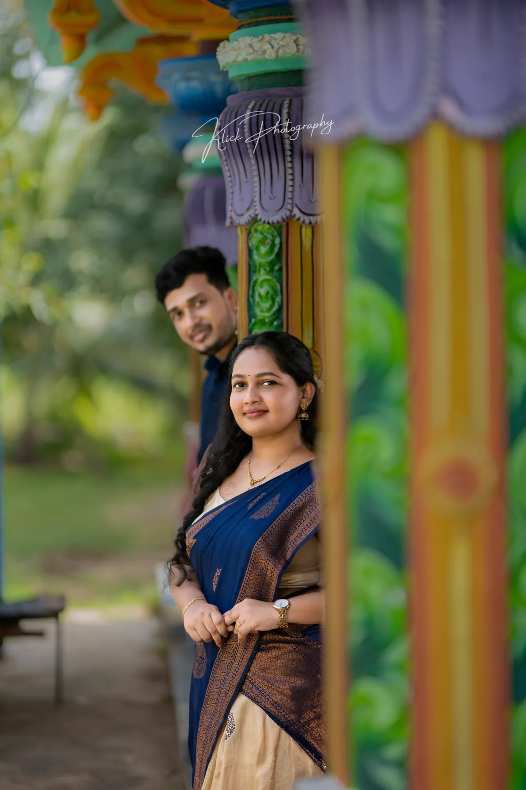 Couple photographed against brightly painted pillars