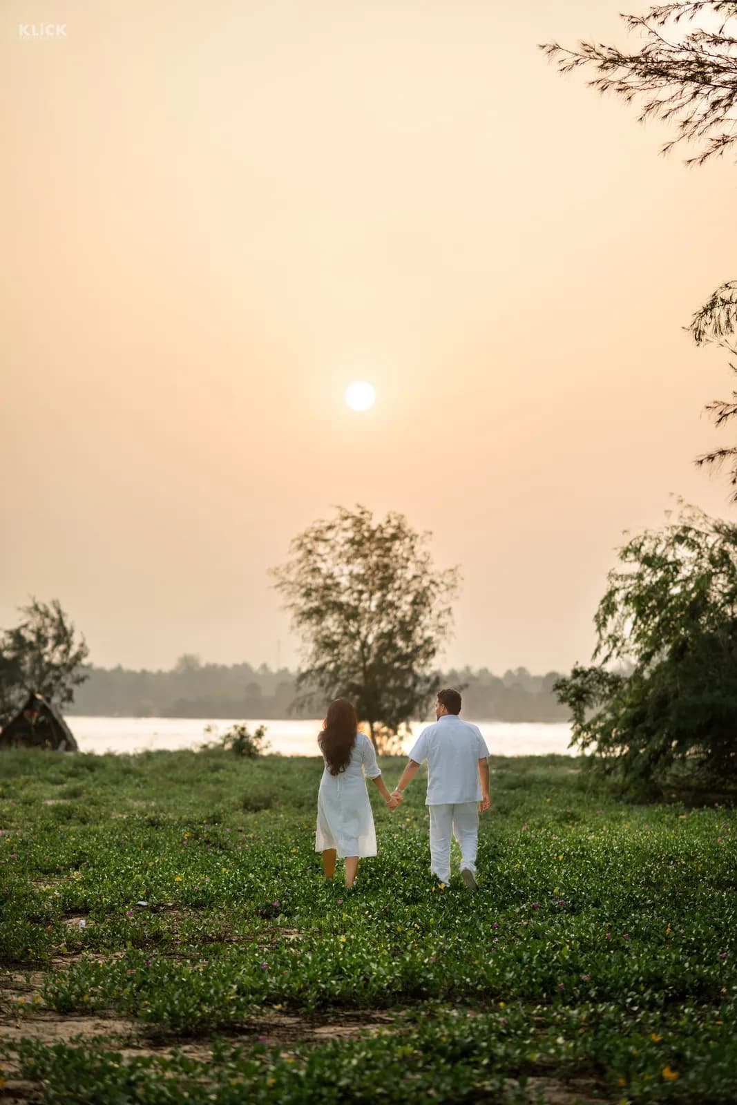 Couple walking towards the lagoon as the sun sets