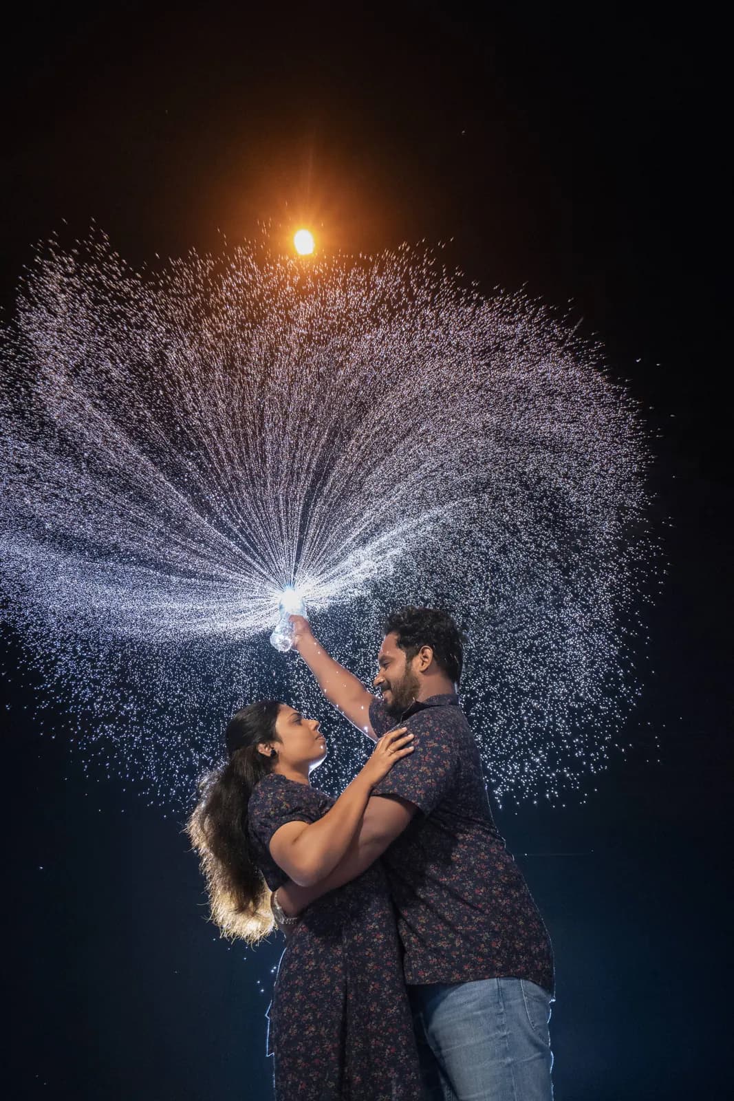 Night portrait of a couple with a sparkler light trail