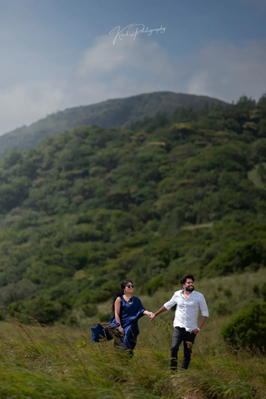 Couple walking a hillside trail on an overcast day