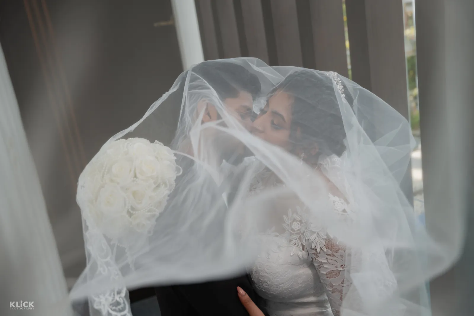 Couple sharing a moment beneath the bridal veil