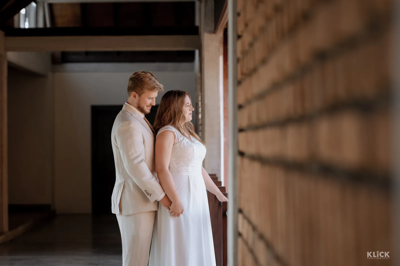 Bride and groom in white standing together before the ceremony